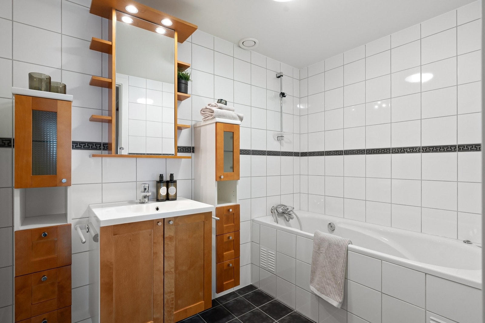 Ett av badene har innmurt baderkar og opplegg for vaskemaskin og tørketrommel, mens øvrige har dusjhjørne. Galleribilde