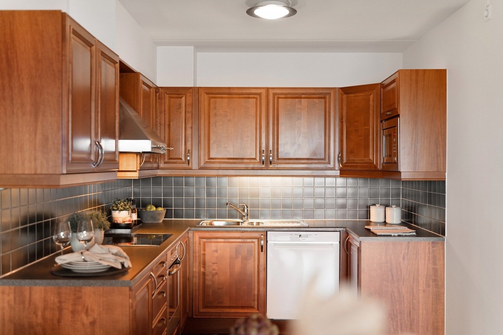 Over kjøkkenbenken er det sorte fliser og innrednigen har et tradisjonelt stiluttrykk. Galleribilde