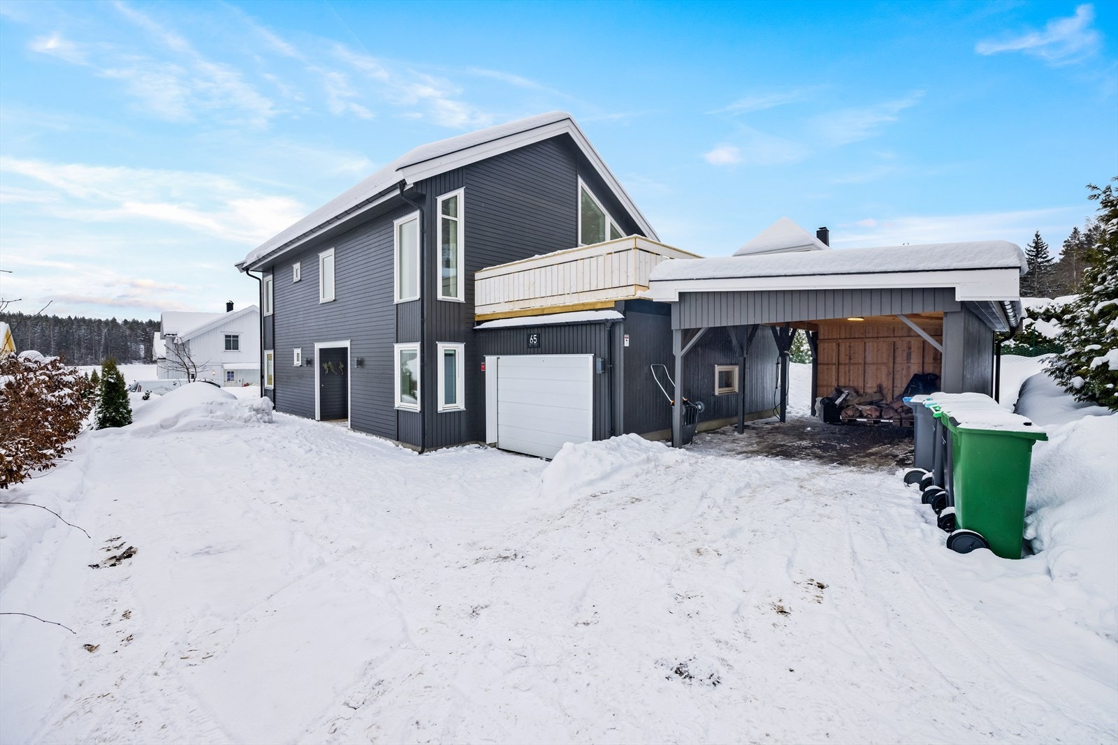 Gårdsplass med god plass til parkering, samt carport med lader og integrert garasje med tilknyttet bod. Galleribilde