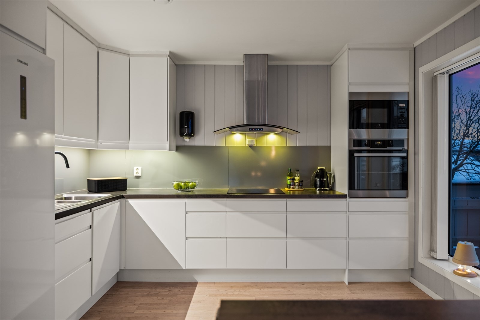 Flott kjøkken fra Epoq med lette fronter, laminat benkeplate og laminatplater mellom benk og overskap. Galleribilde