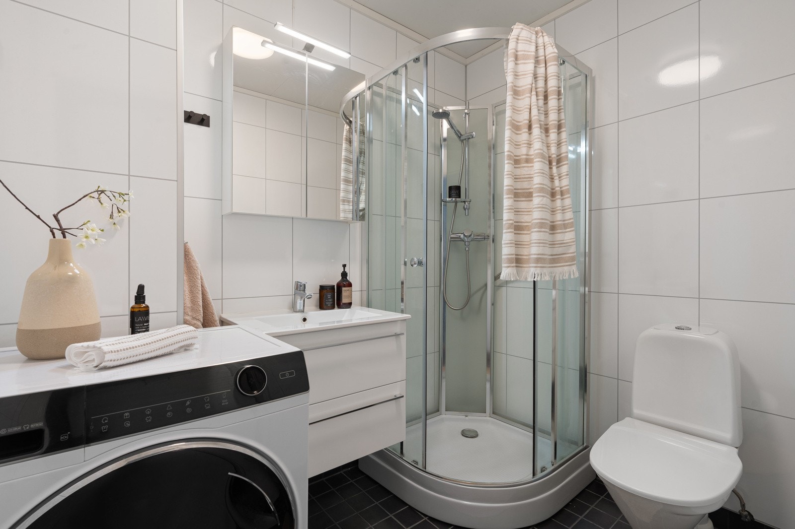 Tidløs baderomsinnredning med skuffer, speilskap og dusjkabinett.