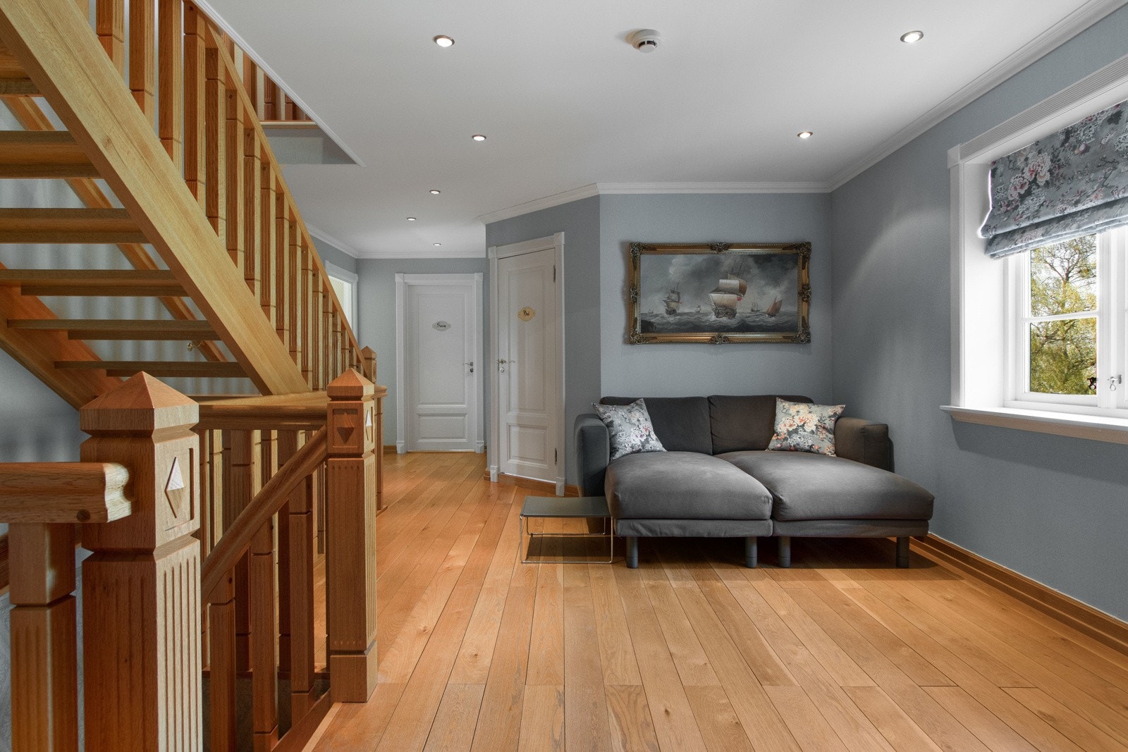 Loftstuen ligger utenfor soverommene og har heltre parkett, downlights og vegger malt i en blå pastelltone. Galleribilde