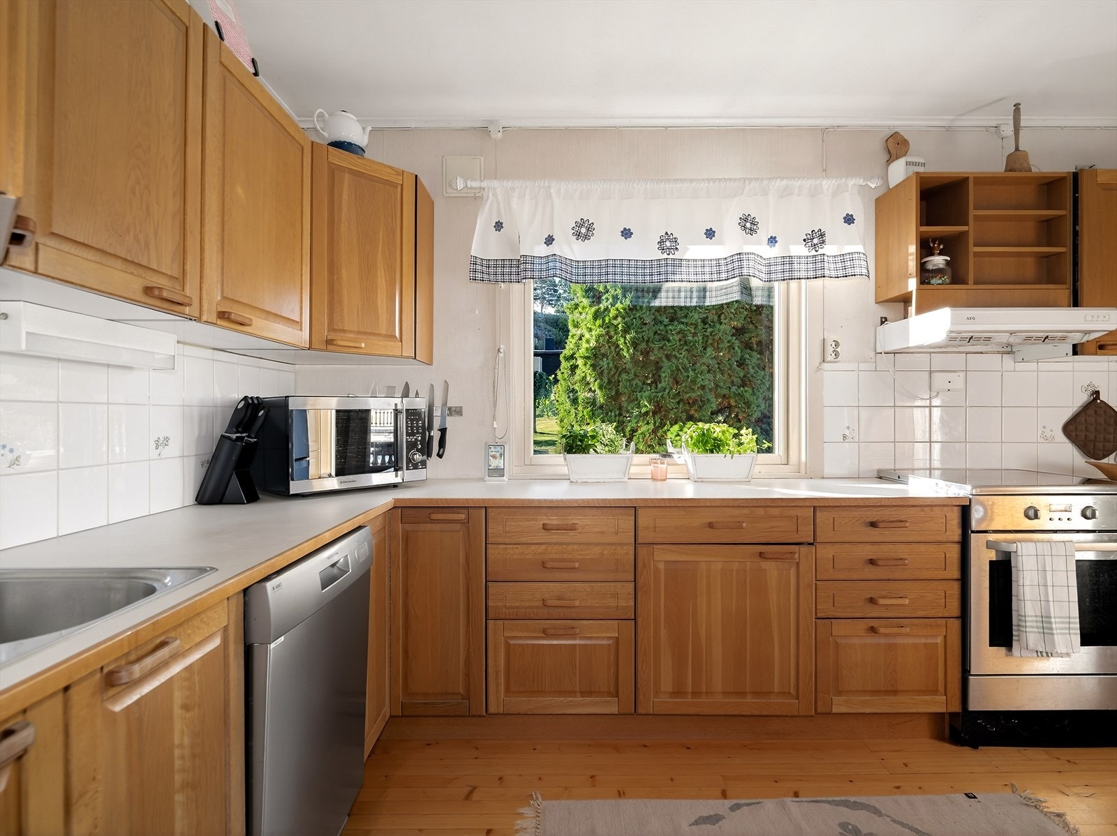 Hyggelig kjøkken med profilert innredning, laminert benkeplate med delvis flis over og nedfelt vask. Galleribilde