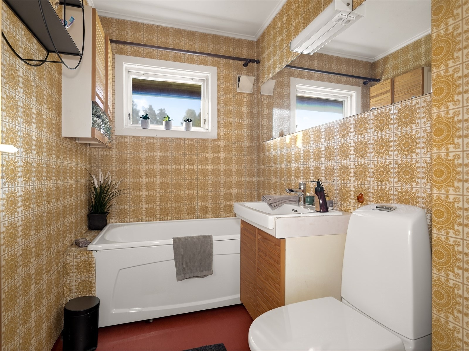 Bad med praktisk tilkomst fra gang med overflater bestående av belegg på gulv, flis på vegg og malt himling. Galleribilde