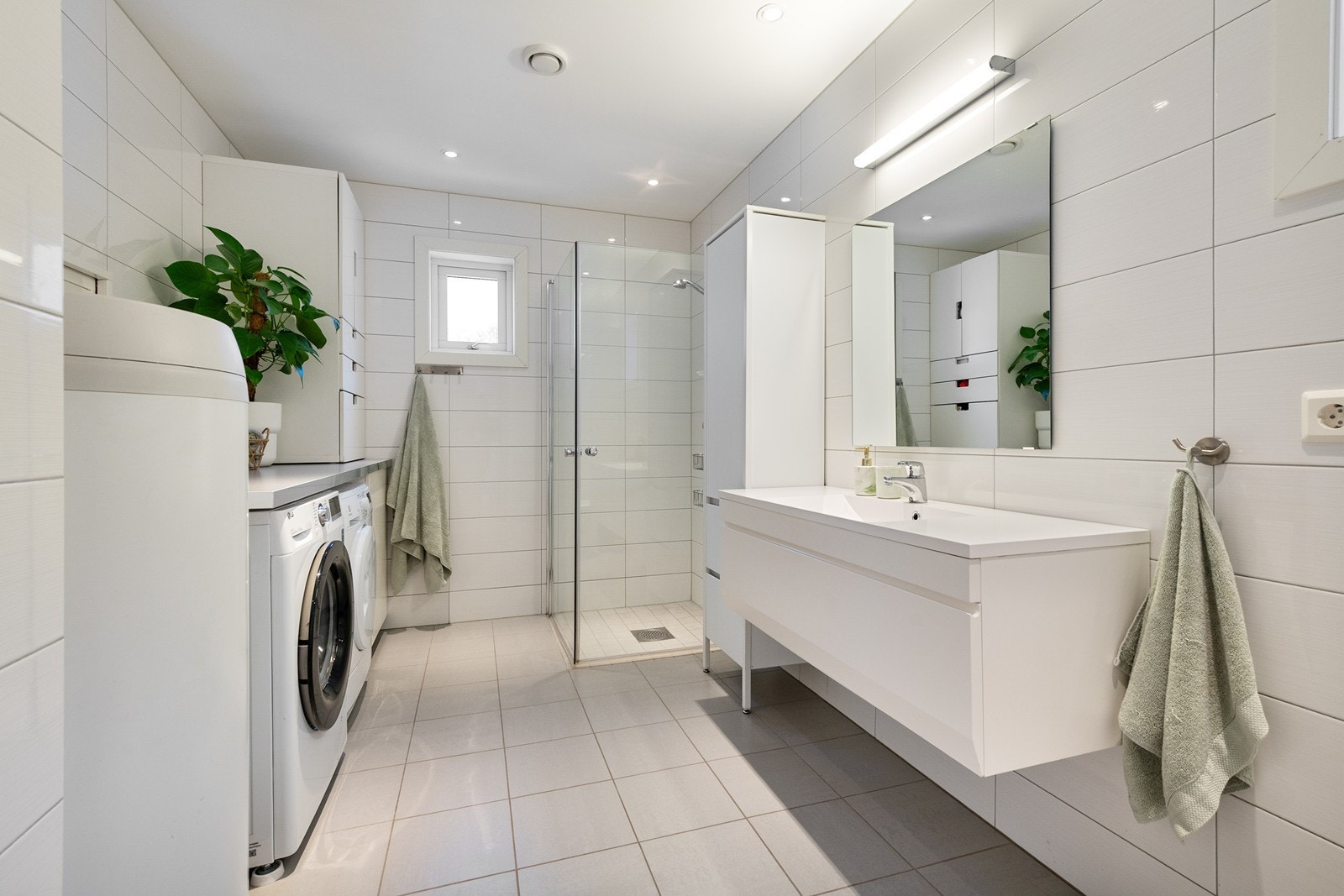 Baderom/vaskerom, med plass til både vaskemaskin, trøketrommel og en liten benk for bretting, luksus Galleribilde