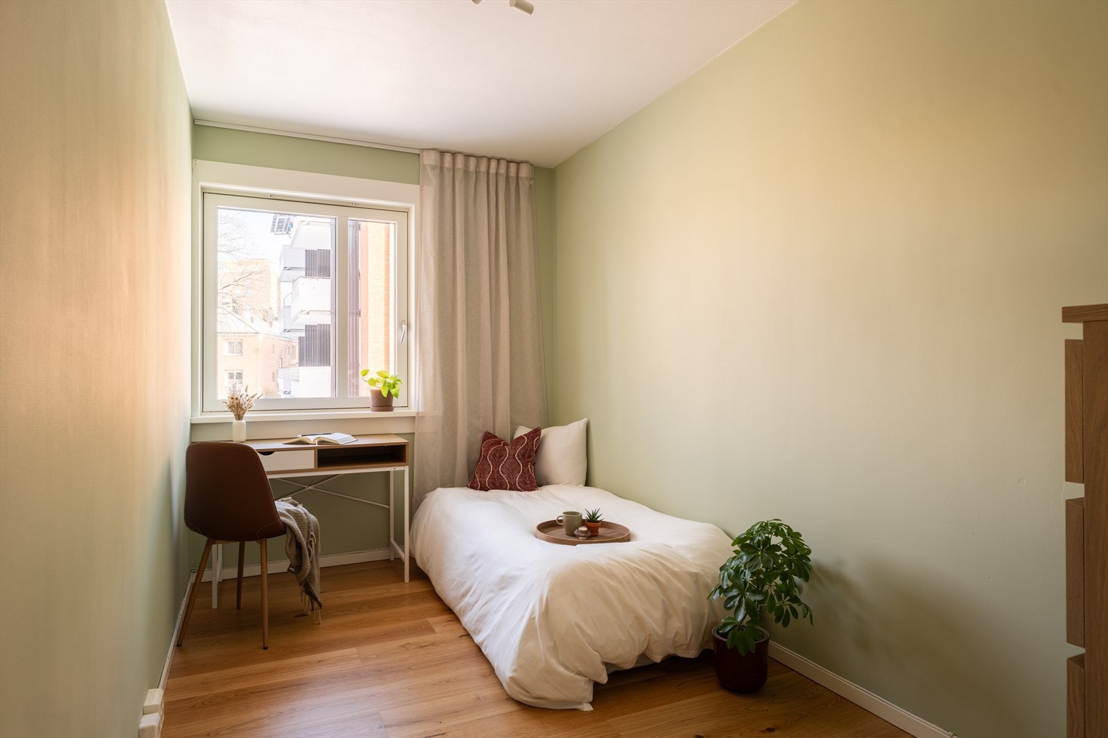 Soverom to er lyst og hyggelig, med duse fargetoner og fint dagslys fra vinduet. Galleribilde