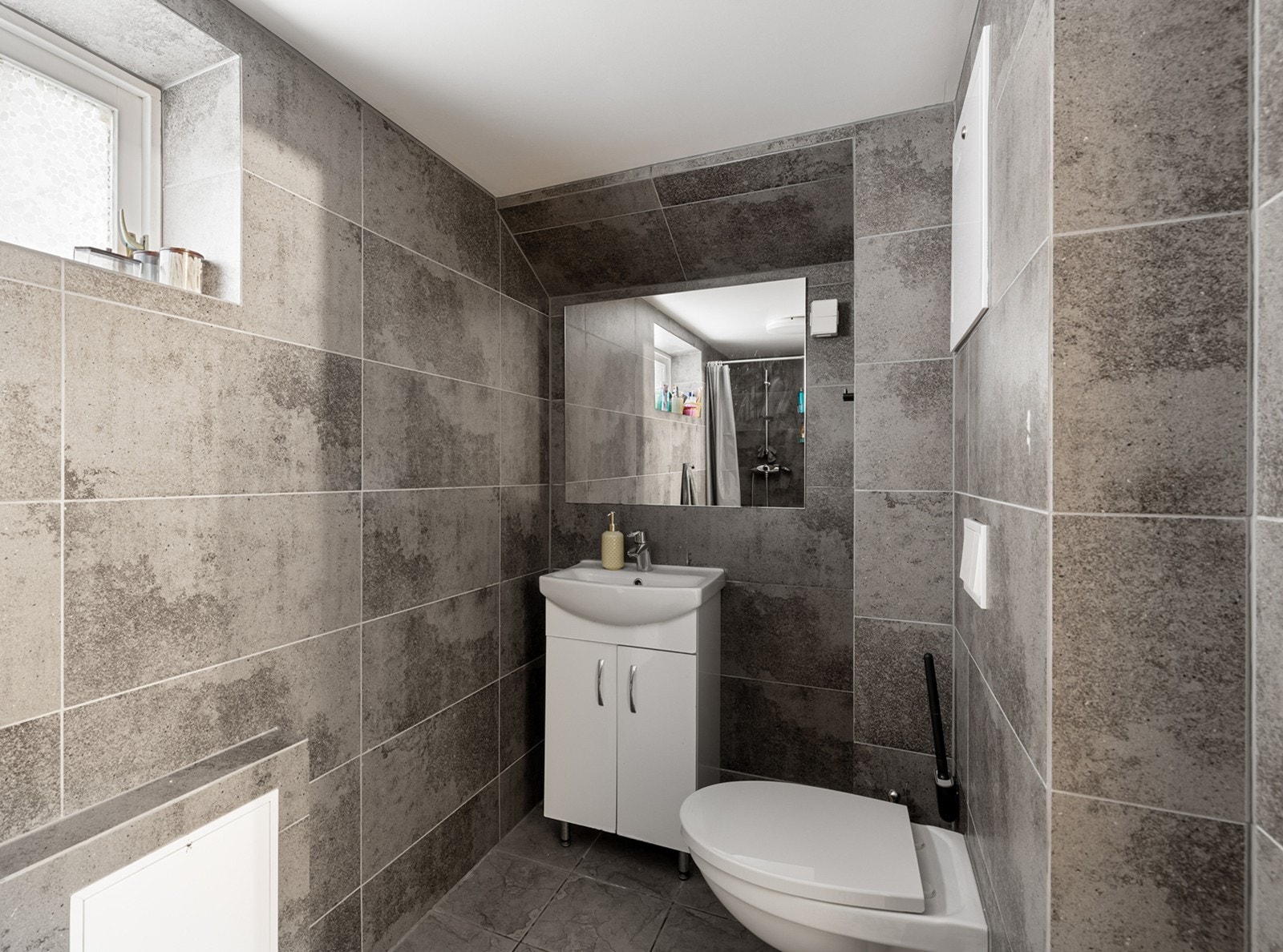 Flislagte vegger og gulv gir et moderne uttrykk på badet. Galleribilde