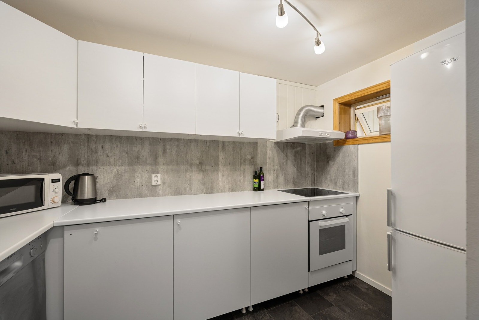 Kjøkkenet har laminert benkeplate og integrert komfyr med nedfelt platetopp. Galleribilde