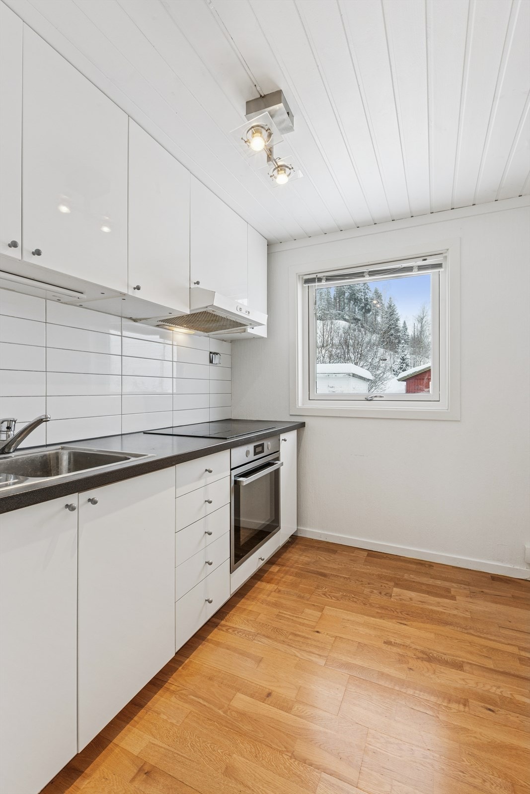 Innredningen har glatte fronter, laminert benkeplate og fliser over benken. Galleribilde