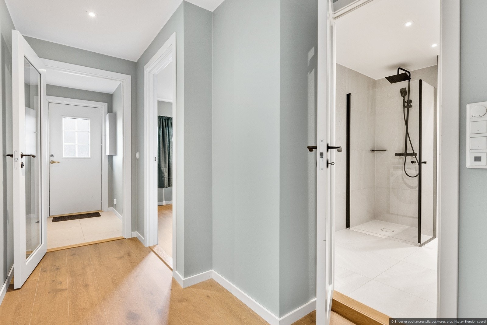 Lyse og delikate flater møter deg i det du entrer inn i vindfang og videre inn i gangen. Ustrakt bruk av downlights. Galleribilde