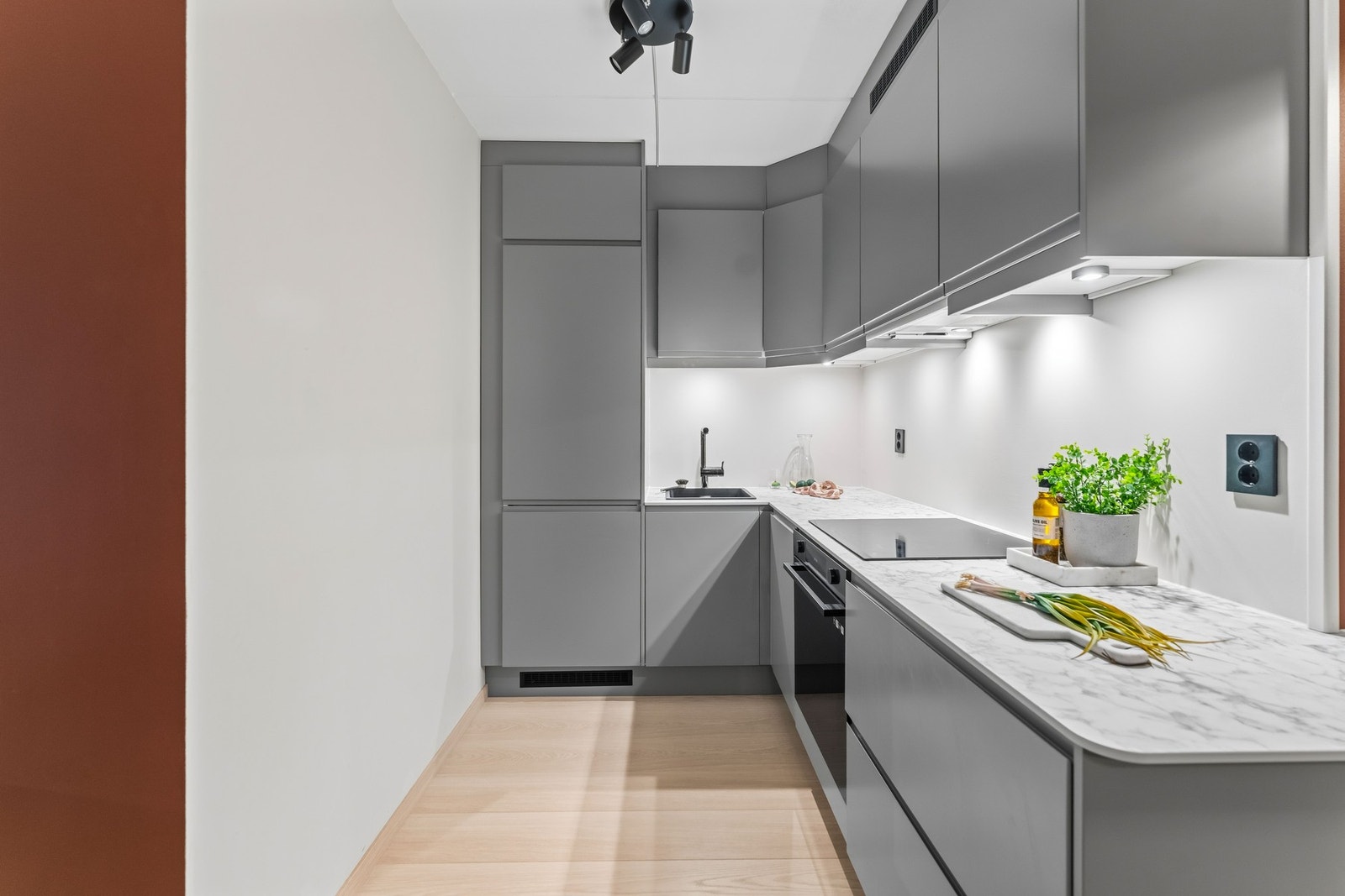 Moderne Epoq-kjøkken fra 2023 med laminat benkeplate og god lagringsplass i skap- og skuffeseksjoner. Det er integrerte hvitevarer som platetopp, stekeovn, oppvaskmaskin og kjøl-/fryseskapoppvaskmaskin. Galleribilde