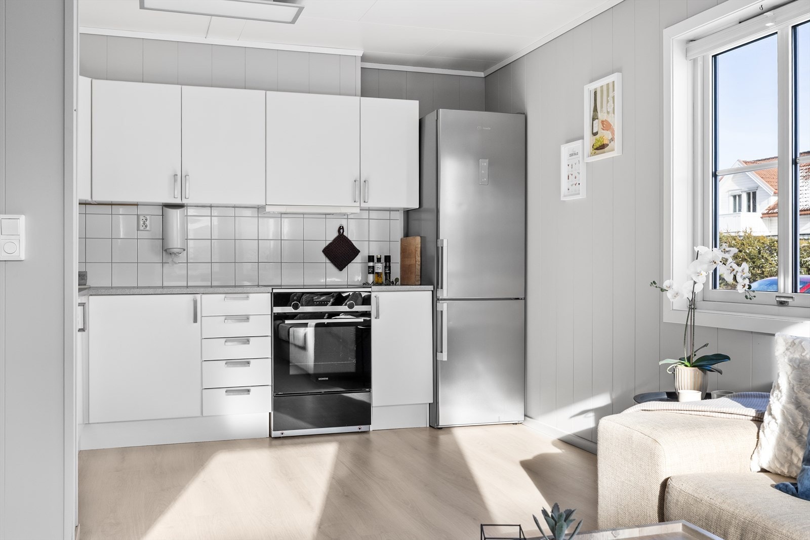 Kjøkkenet har innredning med slette fronter fra byggeår, ventilator over komfyr og opplegg for oppvaskmaskin Galleribilde