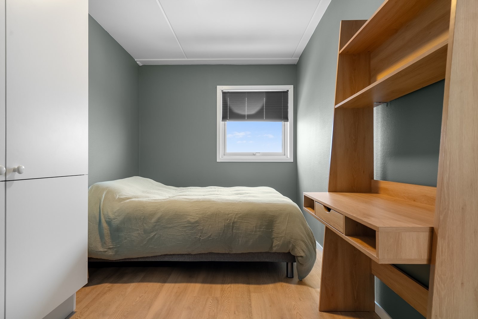 Romslig soverom med rolig fargepalett, gode oppbevaringsmuligheter og plass til praktisk arbeidsplass. Galleribilde