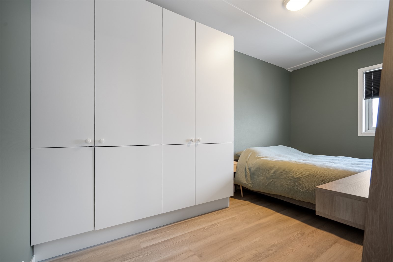 Soverom med garderobeløsning, rolige fargetoner og et behagelig lysinnslipp som gir en lun atmosfære. Galleribilde