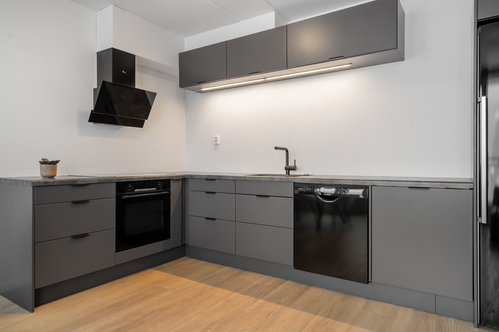 Moderne kjøkken med integrert lys under overskapene som gir meget god belysning. Galleribilde