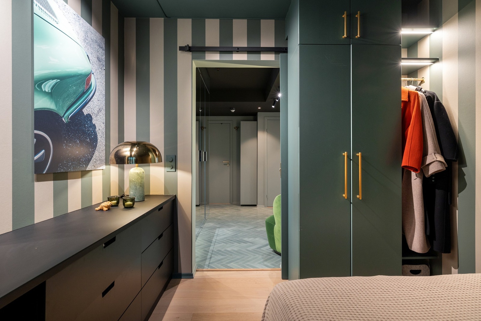 Rommet har en moderne og sofistikert stil med en harmonisk fargepalett dominert av grønntoner, messingdetaljer og sort kontrast. Galleribilde