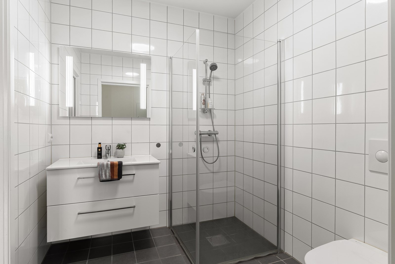 Pent helfliset bad med vegghengt wc, dusjhjørne og varme i gulv for ekstra komfort. Galleribilde