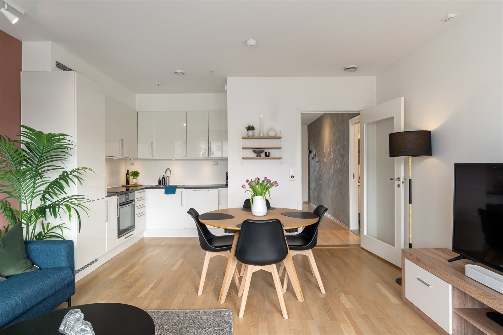 Flott kjøkken med pen kjøkkeninnredning i hvit utførelse og integrerte hvitevarer. Galleribilde