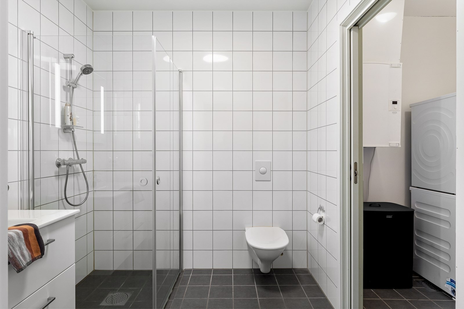 Badet fremstår som arealeffektivt med pen baderomsinnredning i hvit utførelse. Galleribilde