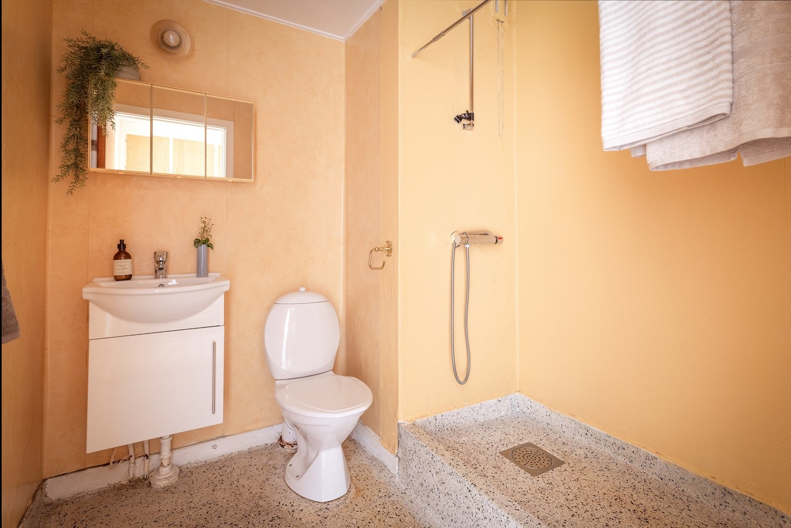 Eldre bad utstyrt med naturlig avtrekk, åpen dusj, wc og servantskap med ett greps blandebatteri fra Grohe. Galleribilde