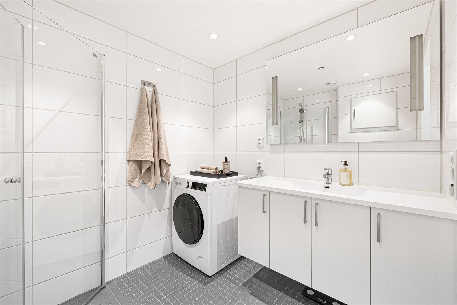 Badet er utstyrt med innfellbare dusjdører, mekanisk avtrekk, toalett, servant i skap, og opplegg for vaskemaskin. Baderomsinnredningen er levert av HTH. Galleribilde