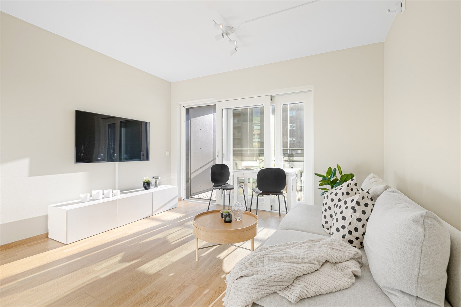 Boligens samlingspunkt inkluderer stue og kjøkken i en åpen løsning på 14,5 m². Allrommet får inn godt med naturlig dagslys fra de store vindusflatene som strekker seg helt fra gulvet og opp til taket, noe som er med på å gjøre boligen lys og trivelig. Galleribilde