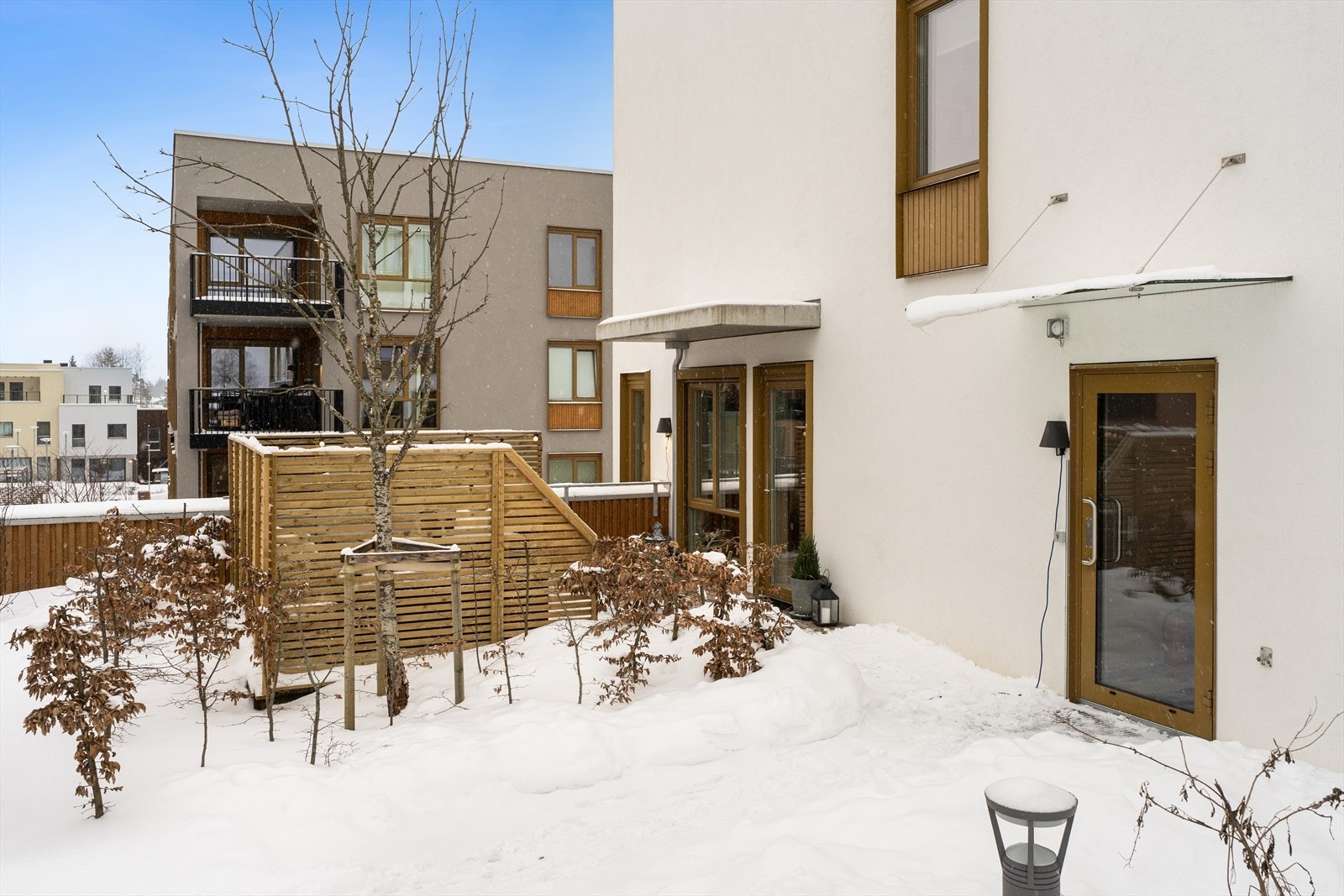 Bildet er fra felles tak og her ser man leilighetens terrasse. Den er skjermet med både levegg samt beplantning. Se også selgers private bilder fra sommeren før leveggen ble montert. Galleribilde