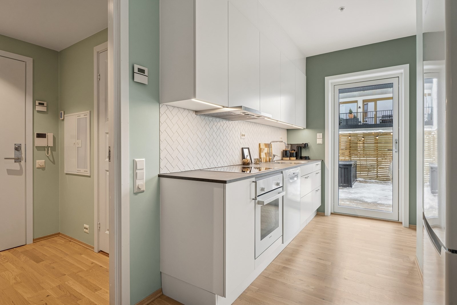 Kjøkkenet har integrerte hvitevarer som platetopp, komfyr og oppvaskmaskin. Galleribilde