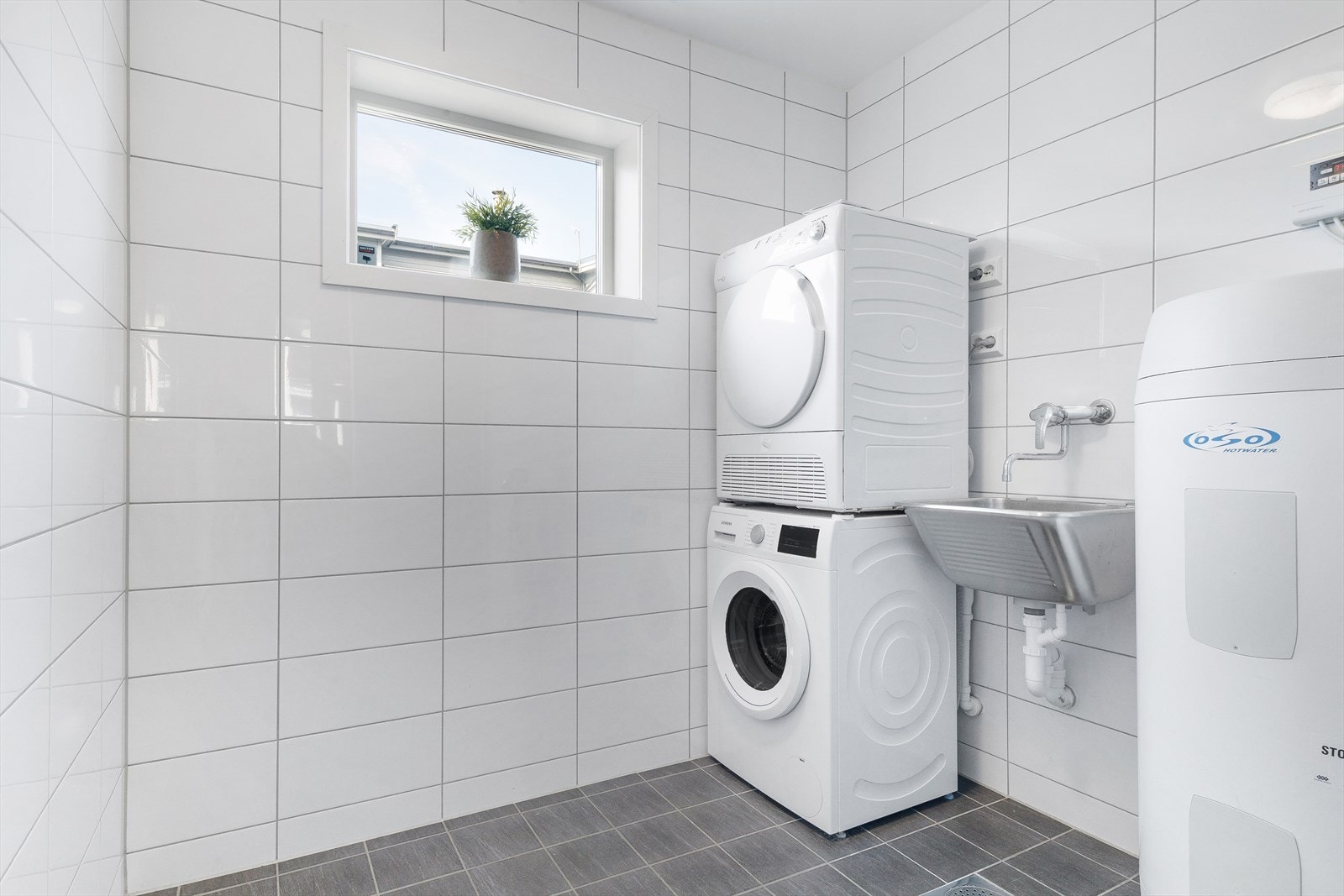 Vaskeromsdel med opplegg for vaskemaskin og tørketrommel, samt utslagsvask. Galleribilde