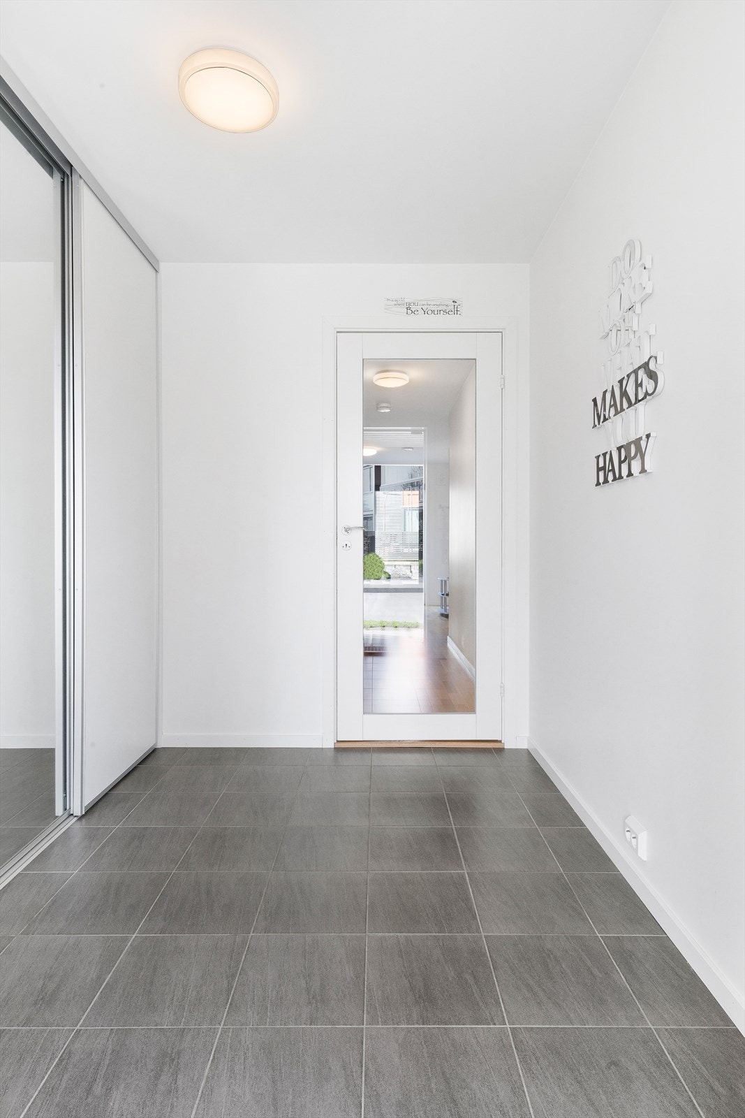 Romslig entré med fliser på gulv. Galleribilde