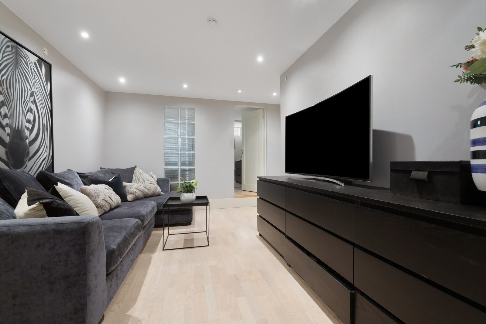 Romslig gang/hall, i dag innredet som tv-stue. 2 stk. innredet rom, og baderom. Galleribilde