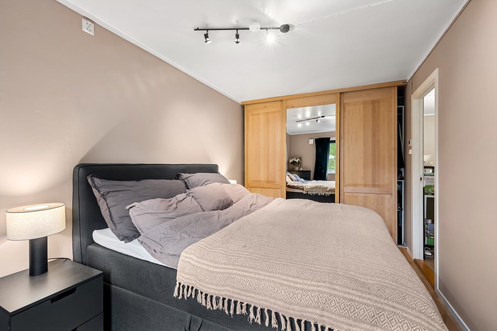 Her er det rikelig med plass for dobbeltseng, nattbord og en stor innebygget skyvedørsgarderobe. Galleribilde