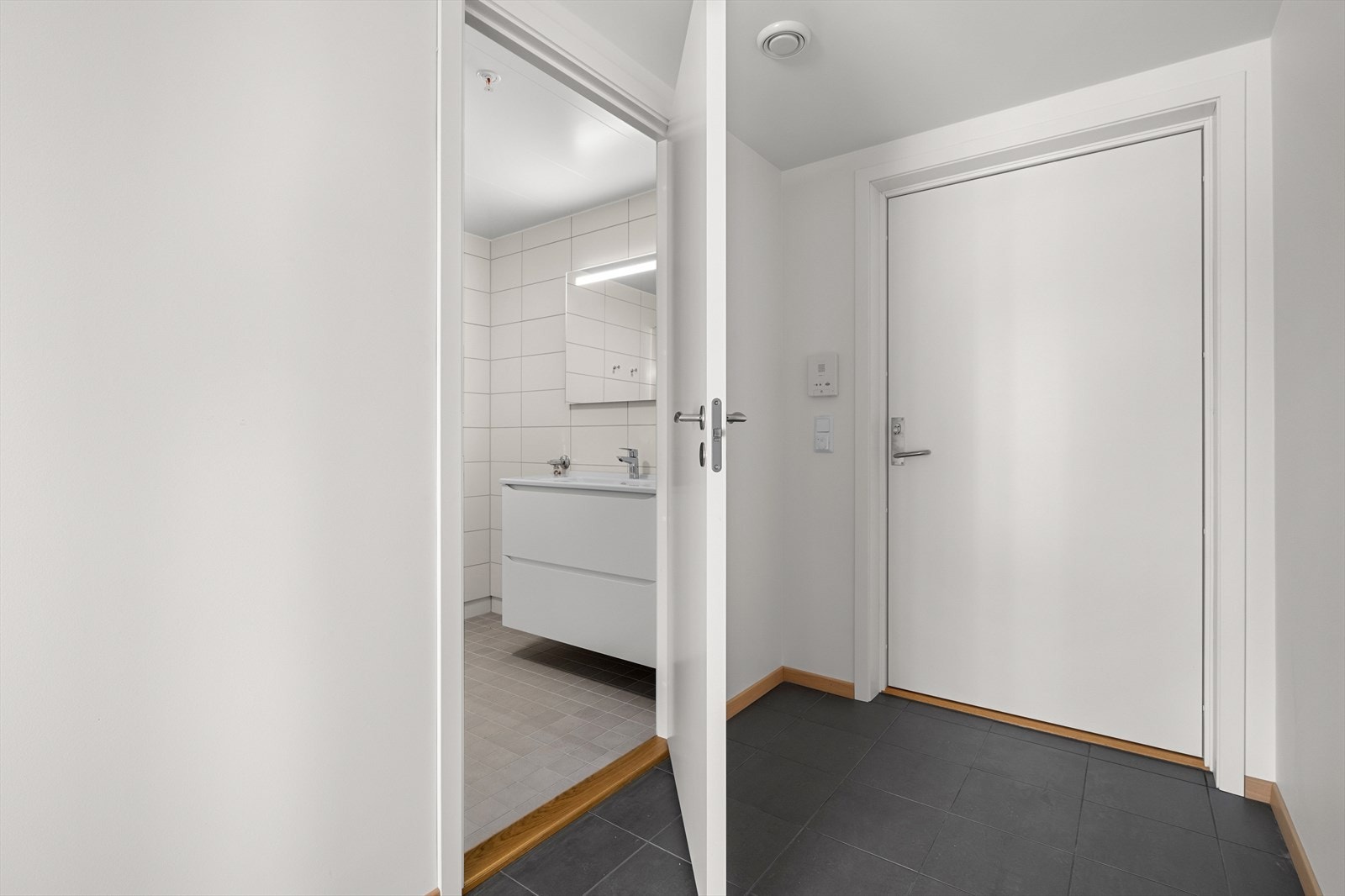 Praktisk flislagt entré med plass til klesoppheng Galleribilde