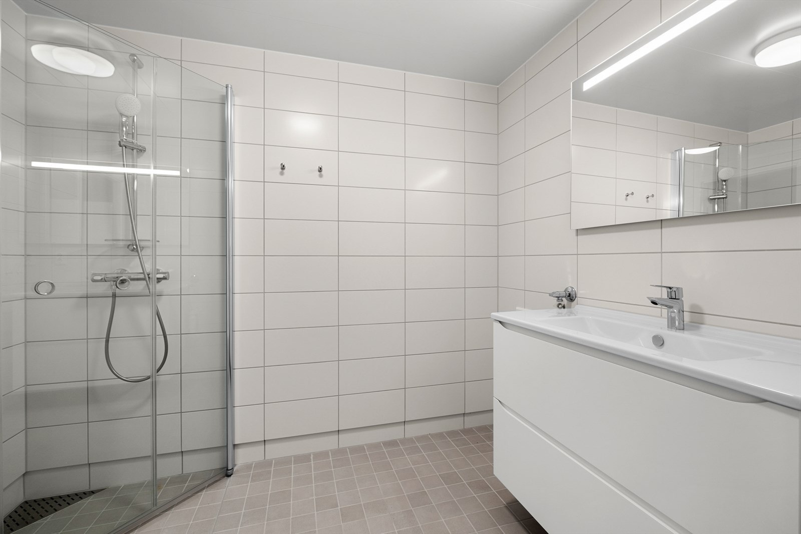 Pent flislagt bad med varme i gulv og opplegg til vaskemaskin Galleribilde