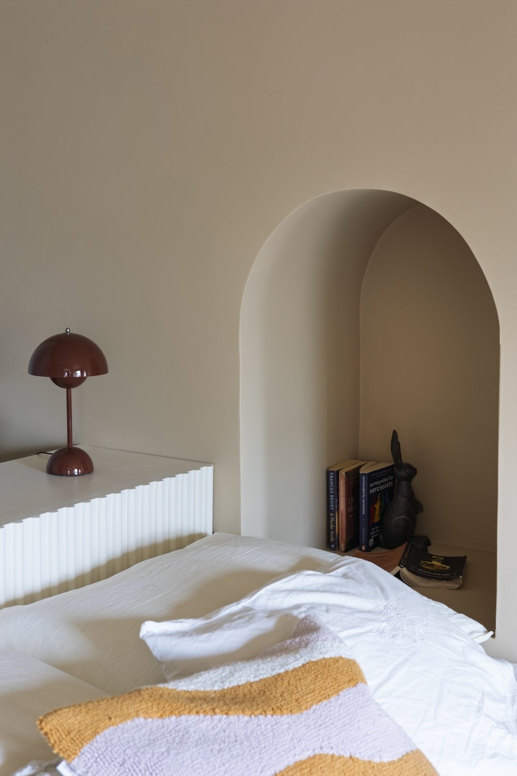Ved sengen finner du et buet nattbord som harmonerer med leilighetens øvrige buede detaljer. Galleribilde