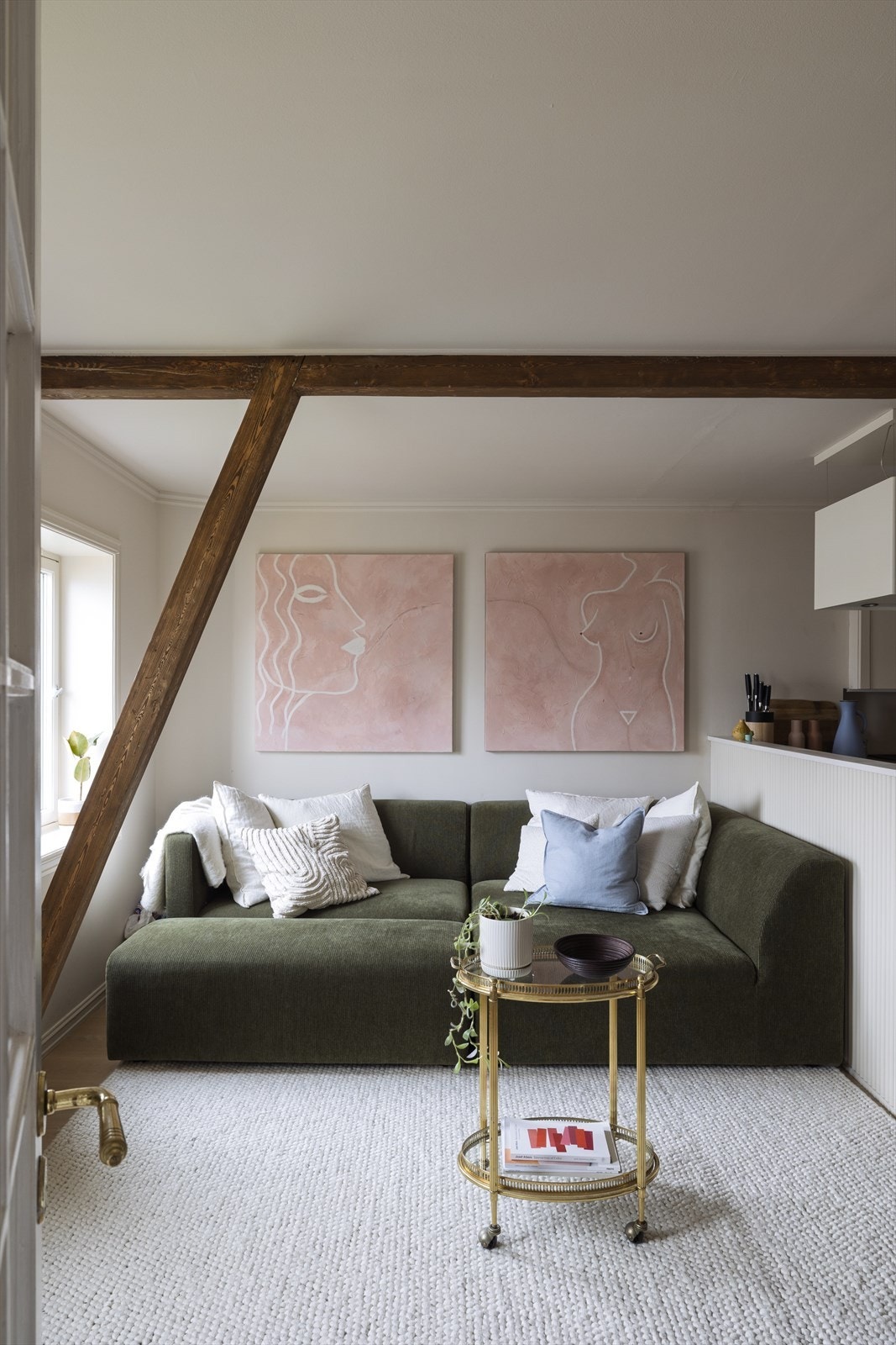 Lys og innbydende stue med synlige takbjelker som gir rommet særpreg og karakter. Galleribilde