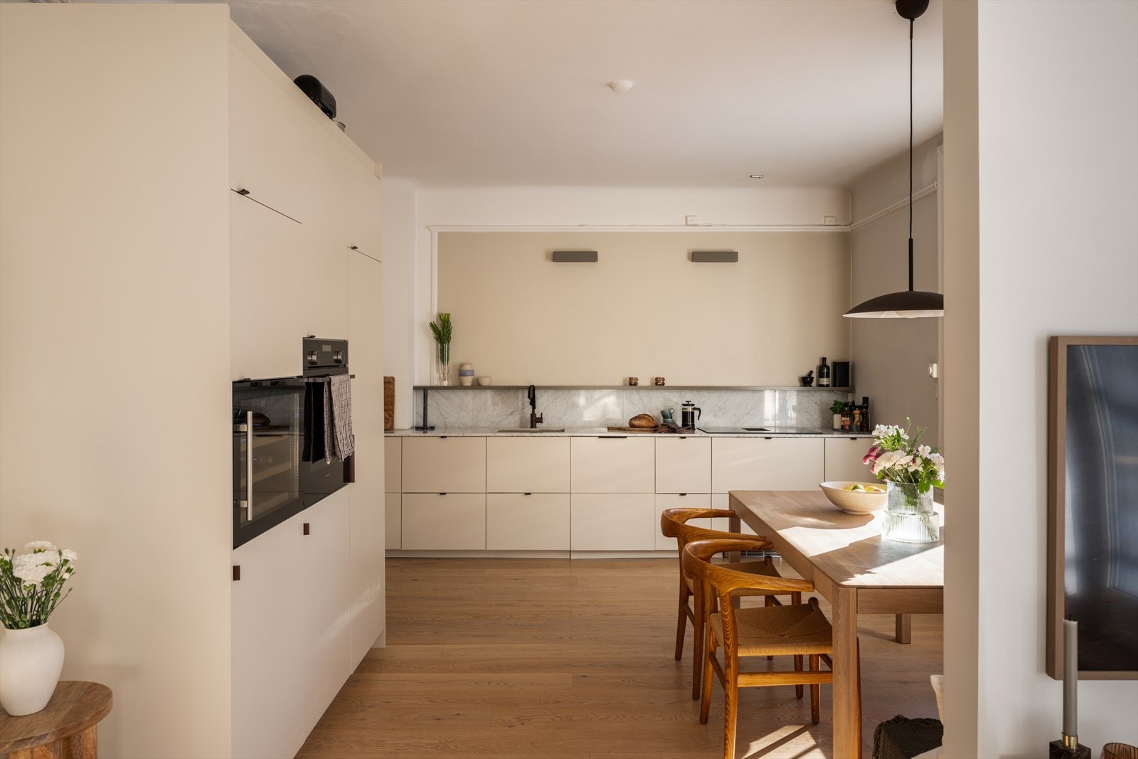 Integrerte hvitevarer som stekeovn, vinskap, induksjonstopp med innebygd ventilator fra (2021), oppvaskmaskin og kjøl/-fryseskap. Galleribilde