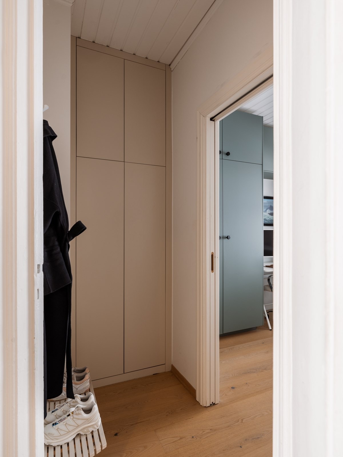 Delikat og plassbygget skap i gangen med skjult opplegg for vaskemaskin på innsiden. Galleribilde