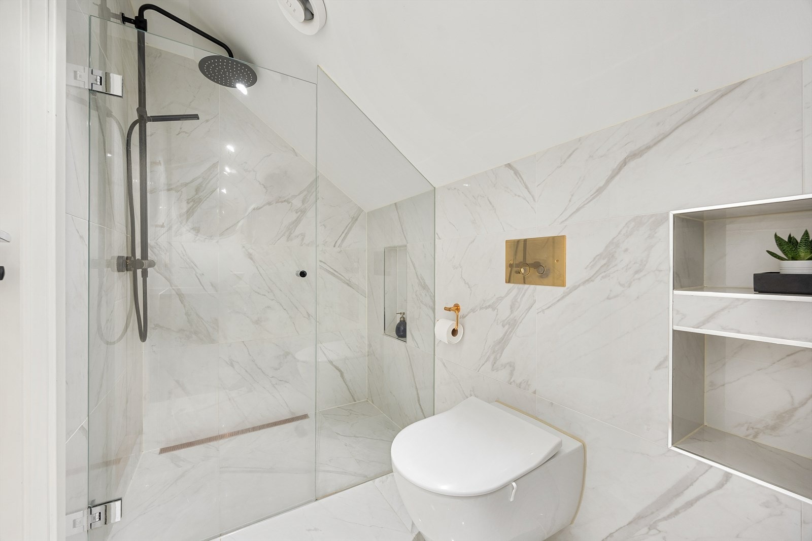 Innredningen består av dusjhjørne med nedsenket gulv og glassdører, vegghengt toalett og servant på laminatbenkeplate. Galleribilde