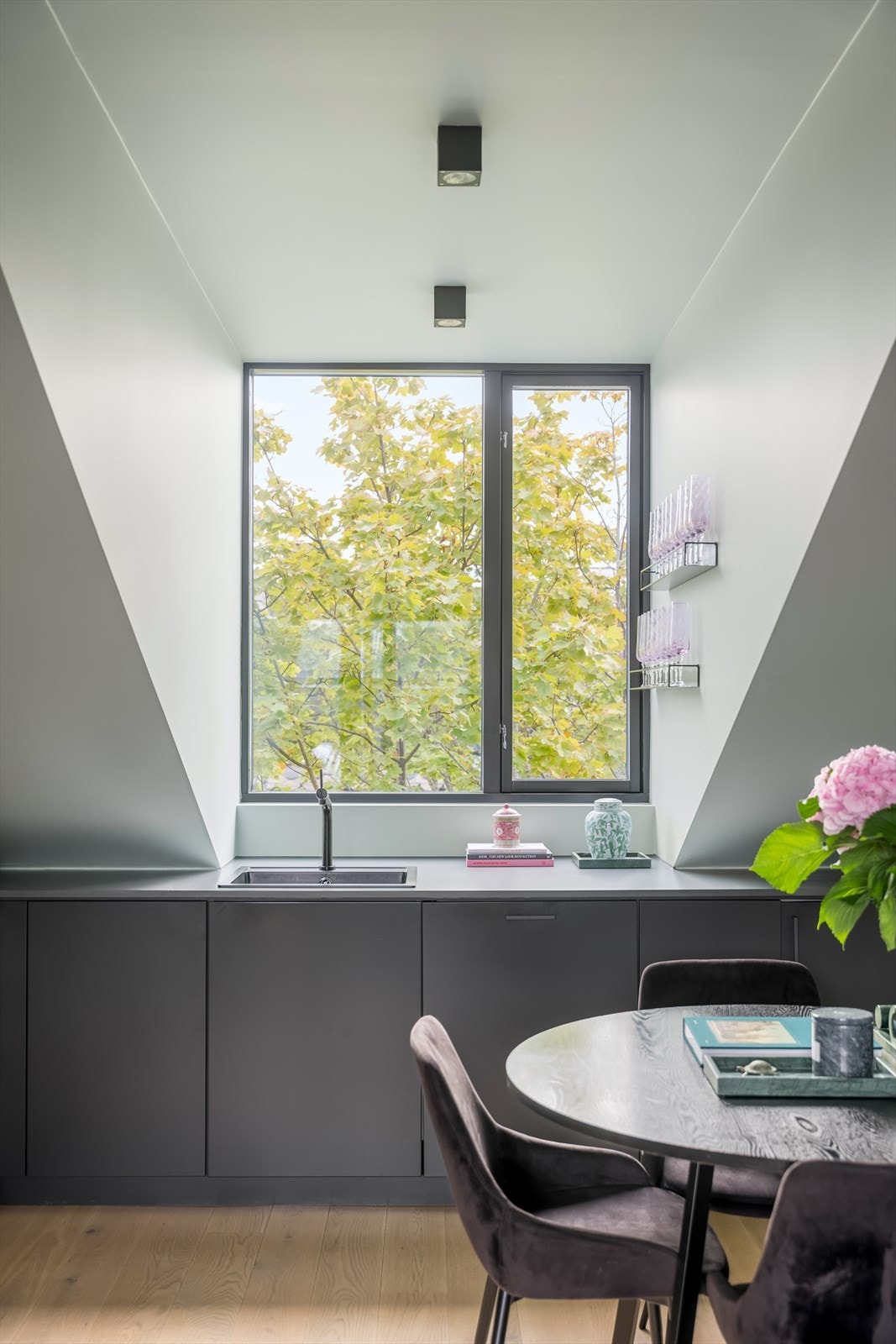 Det store treet utenfor kjøkkenvinduet tilfører rommet et grønt preg og naturlig variasjon gjennom årstidene. Galleribilde