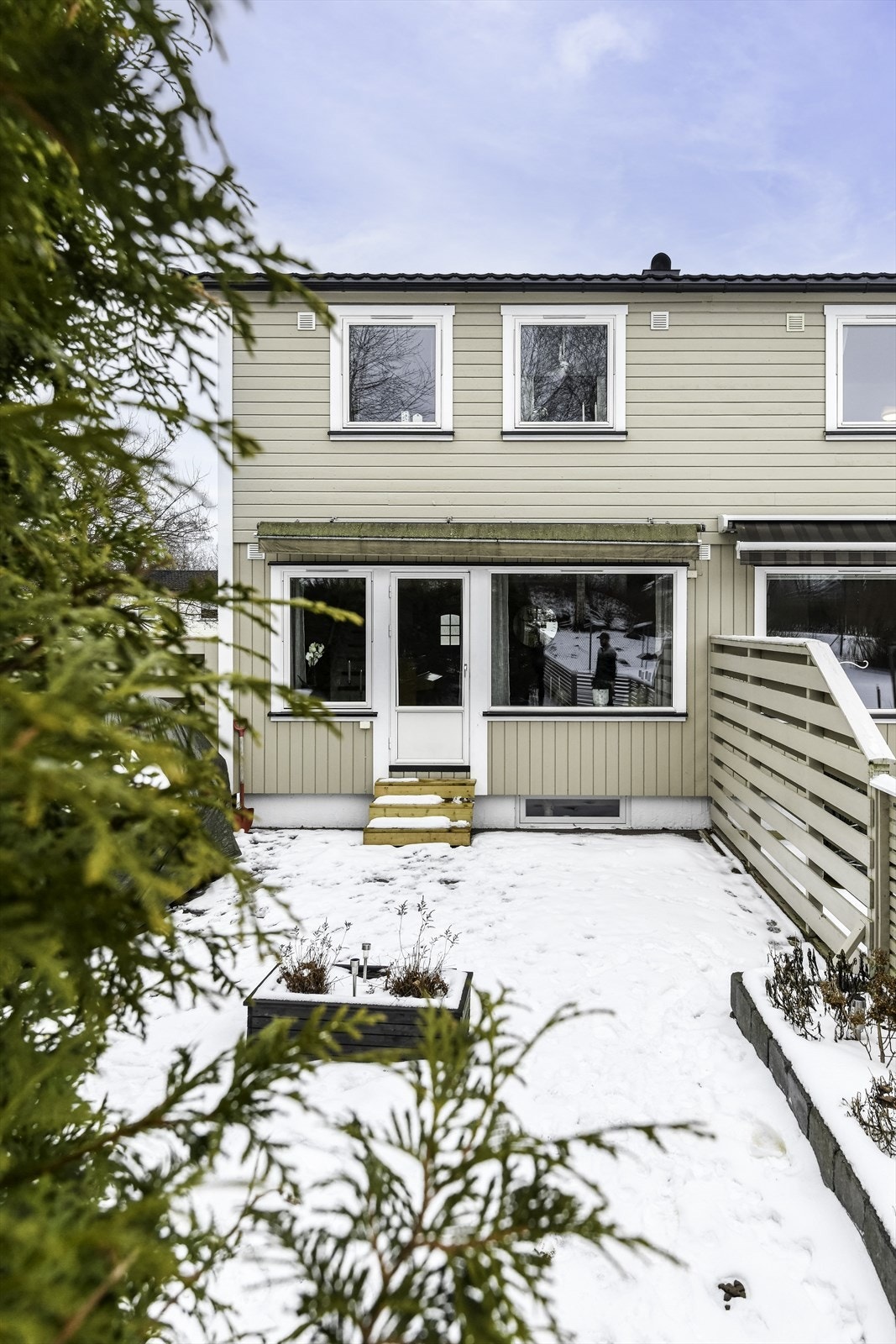 Terrassen i trekonstruksjon har utgang fra stuen og er skjermet av gjerde. Galleribilde