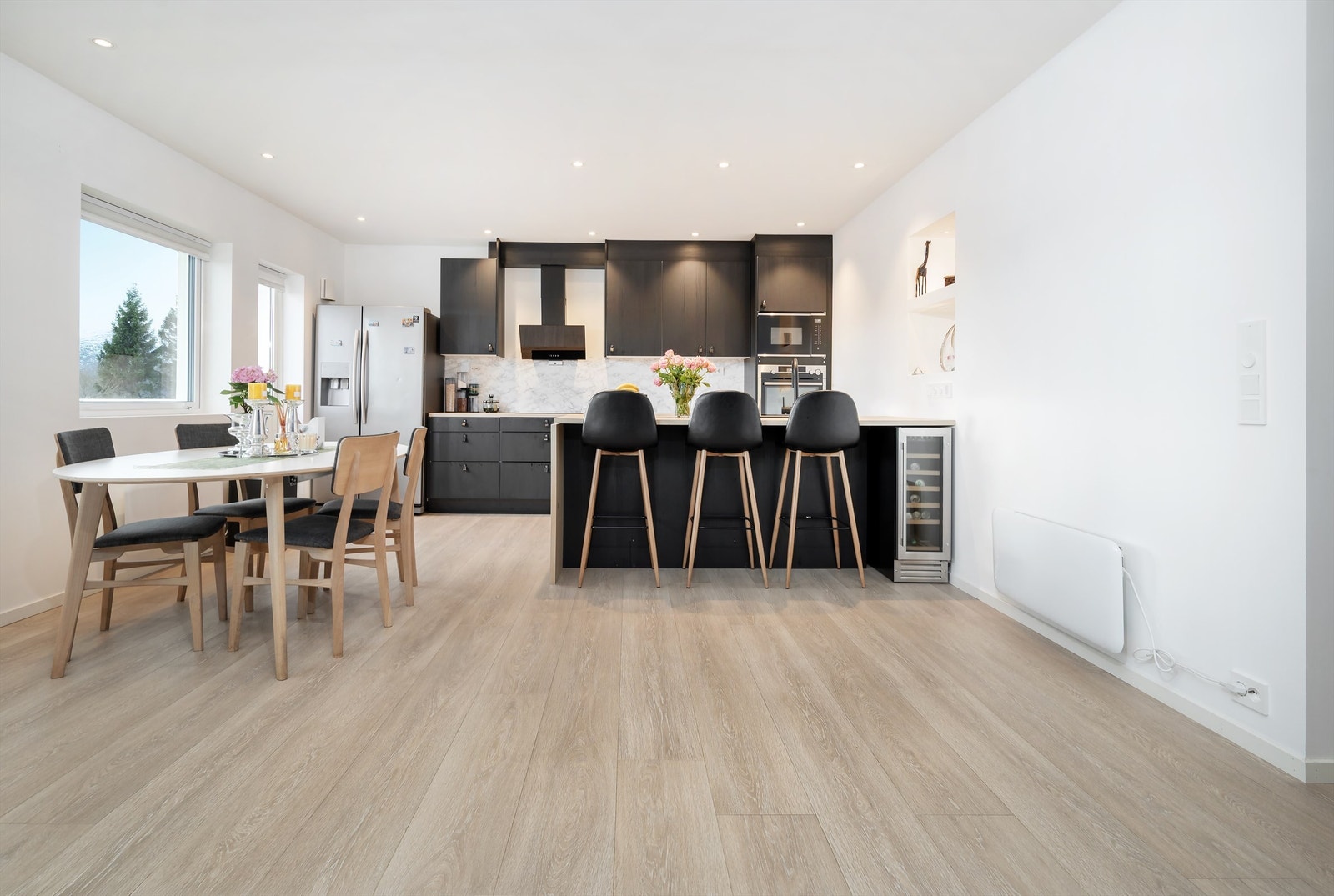 Stuen er i åpen løsning mot kjøkken og det er god plass til spisebord i tilknytning til kjøkken samt sitteplasser ved kjøkkenhalvøy Galleribilde