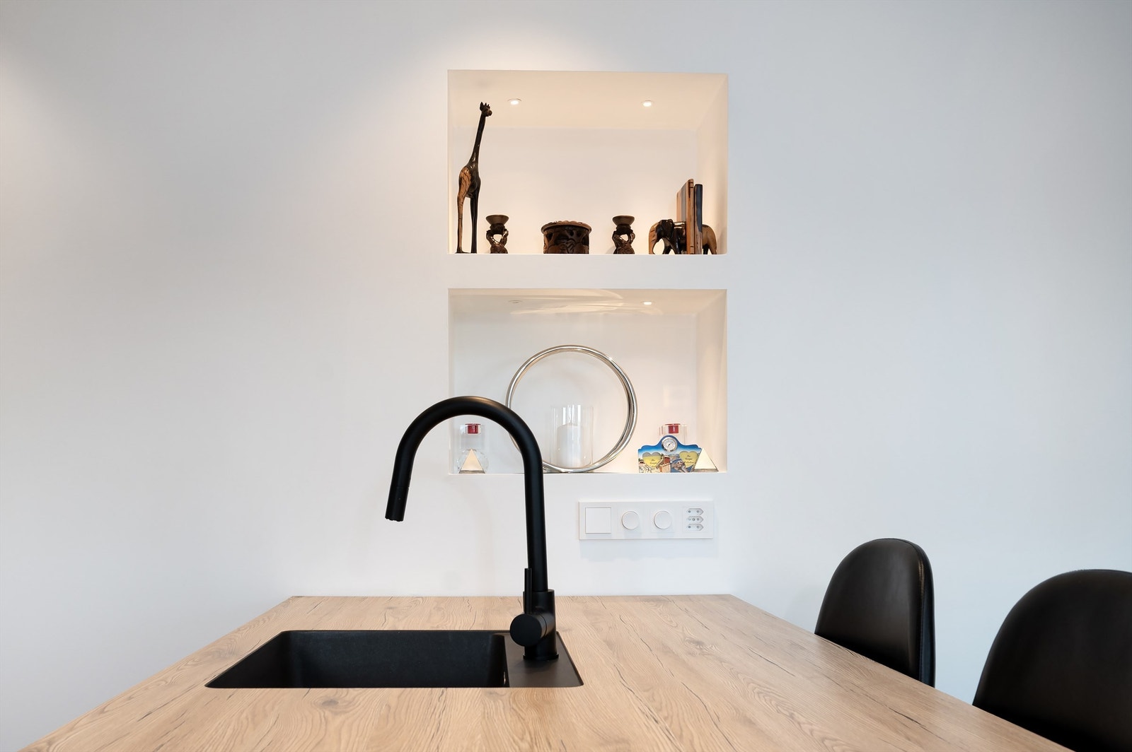 Innfelte, belyste hyller i veggen gir en dekorativ og praktisk oppbevaringsløsning. Galleribilde