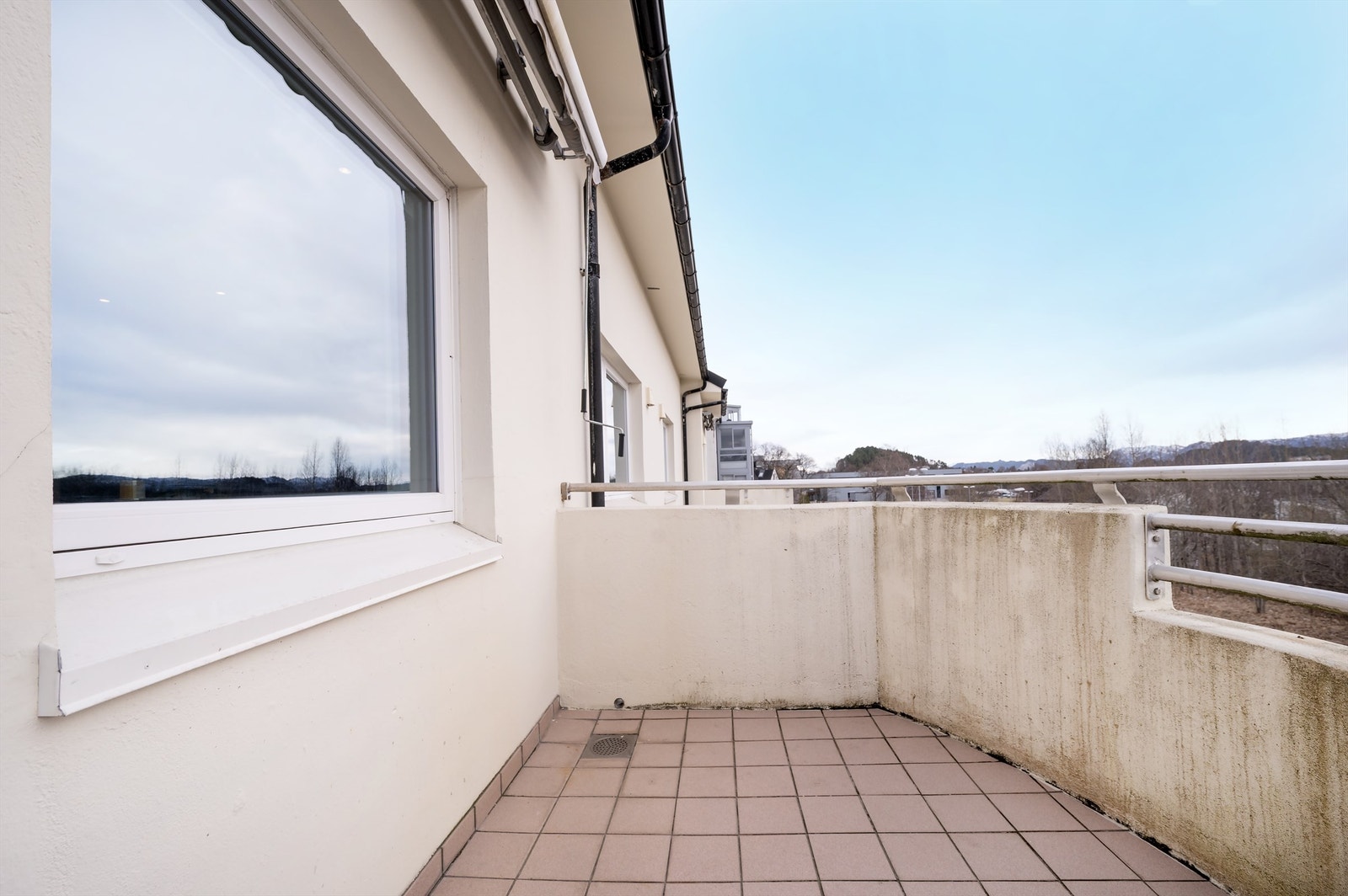 Balkongen har flislagt gulv og plass til en sittegruppe. Galleribilde