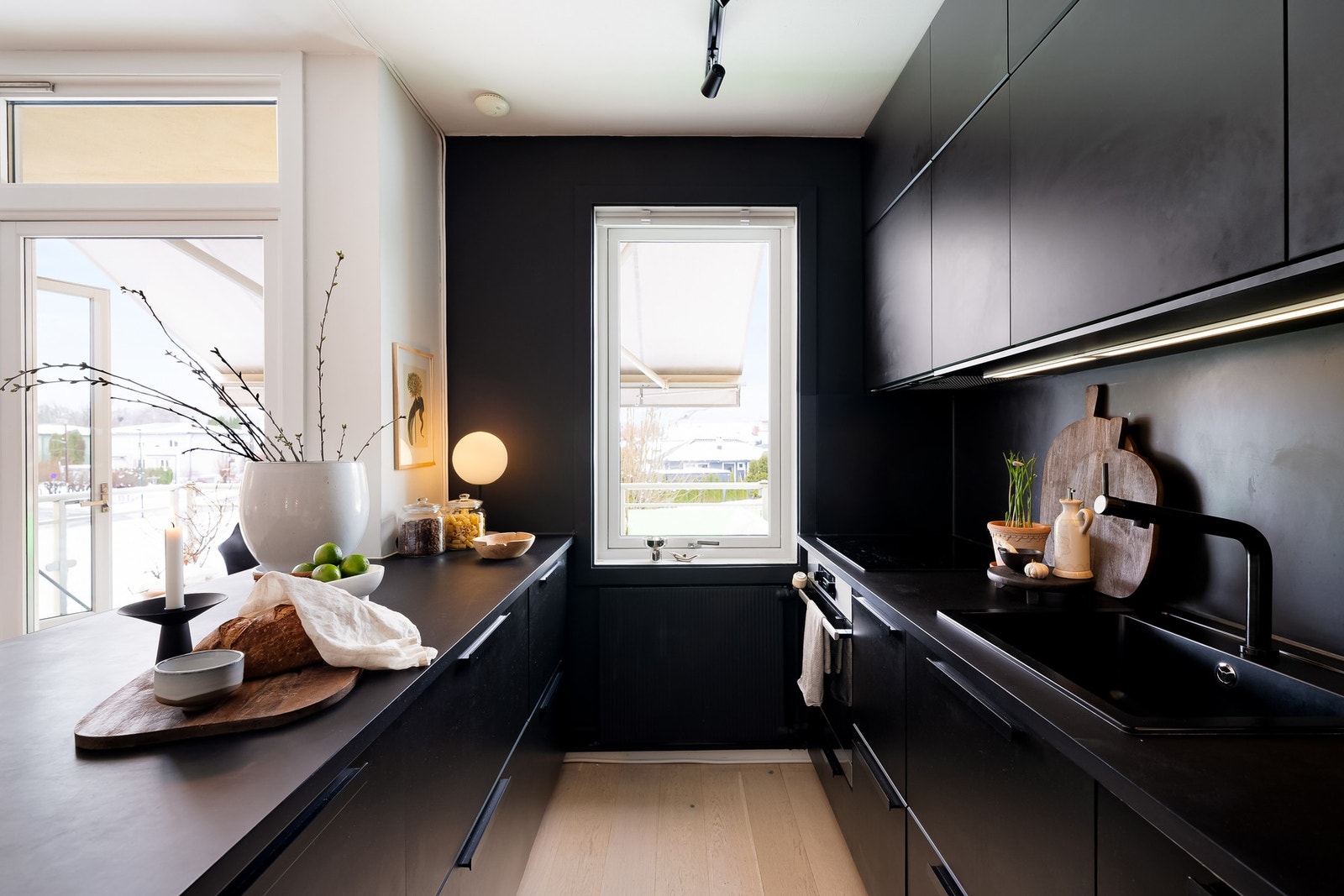 Stilren kjøkkeninnredning med glatte fronter og laminat benkeplate med topplimt vask. Galleribilde