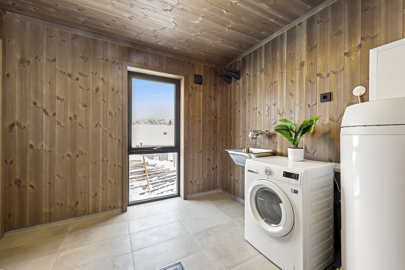 Hytta har et funksjonelt teknisk rom med egen inngang, noe som gjør det enkelt å oppbevare utstyr og holde orden. Her er det opplegg for vaskemaskin og god plass til oppbevaring. Galleribilde