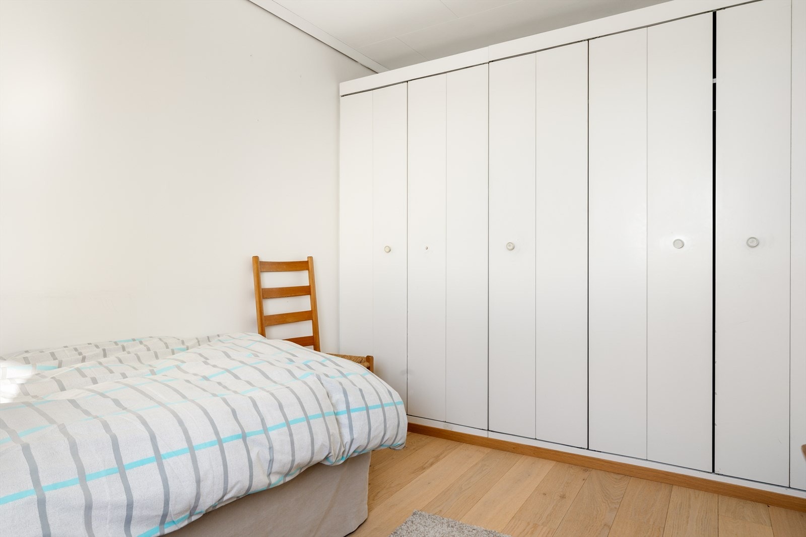 Soverom med plassbygget skap i boligens underetasje. Galleribilde