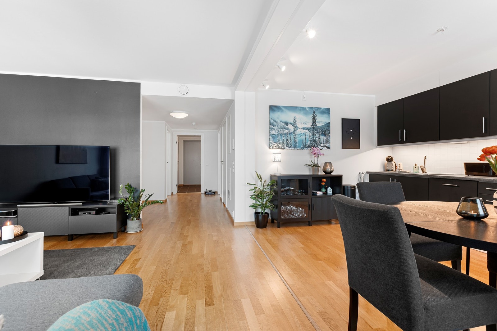 Romslig og moderne stue med en gjennomtenkt planløsning som kombinerer stue og kjøkken i en åpen og sosial løsning. Galleribilde