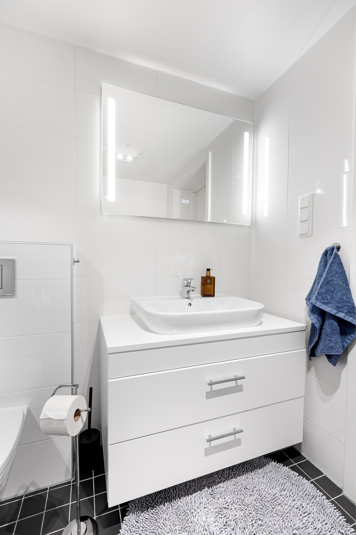 Pen innredning med to skuffer og heldekkende servantplate. Speil med belysning over. Galleribilde