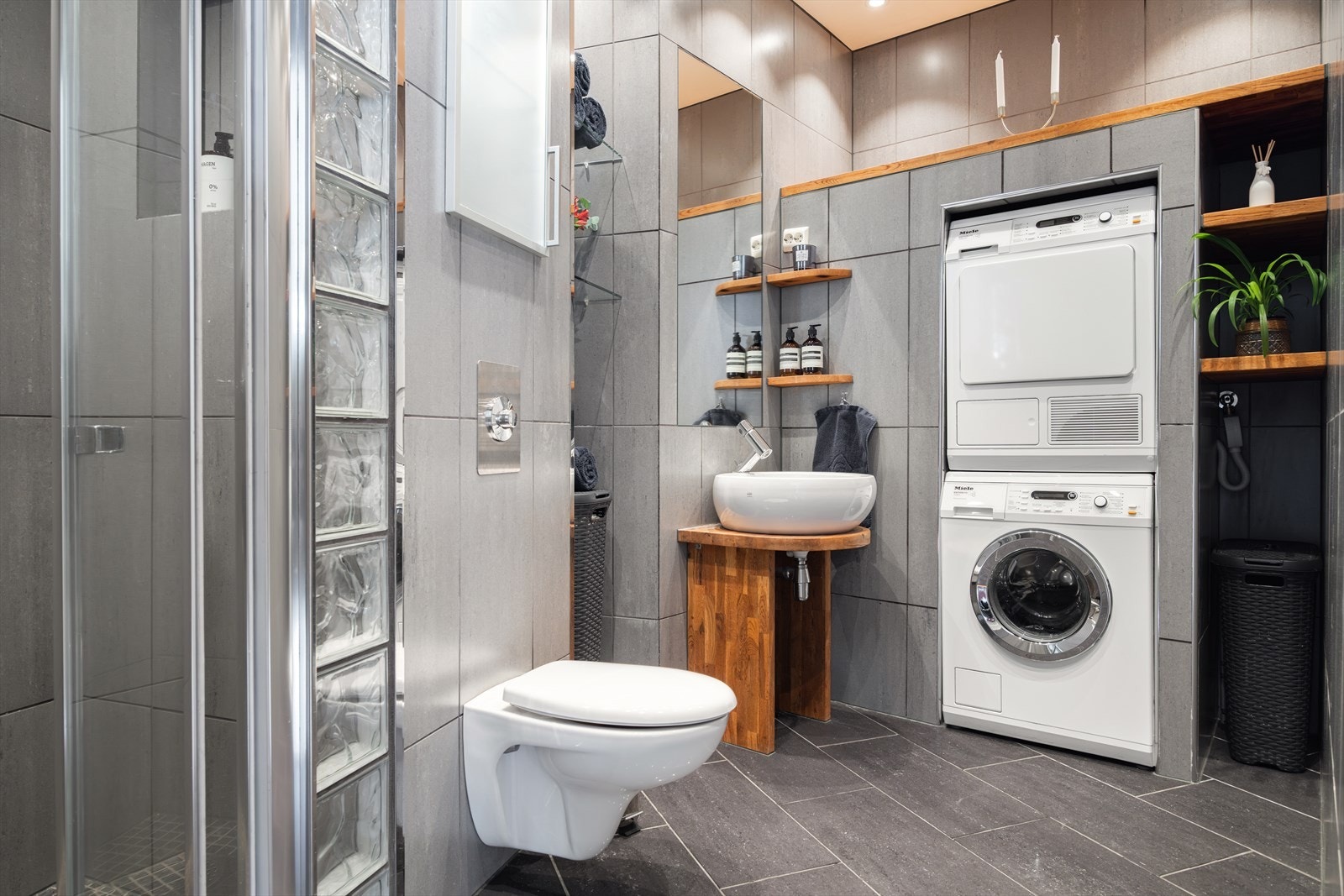 Bad nr. 2. Moderne, flislagt baderom med opplegg for vaskemaskin og tørketrommel i egen nisje. Galleribilde